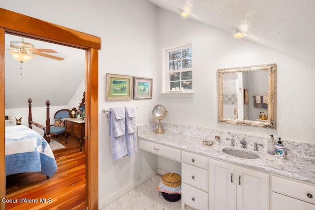 bathroom with ceiling fan, lofted ceiling, and vanity