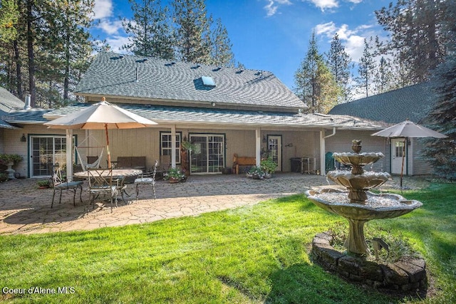 rear view of property featuring a patio area and a yard