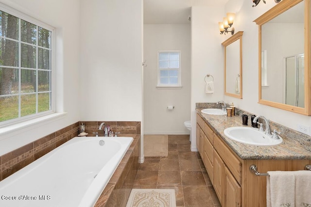 bathroom featuring toilet, tile patterned flooring, tiled tub, and vanity