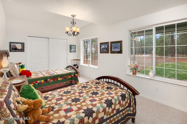 carpeted bedroom with a closet and a chandelier