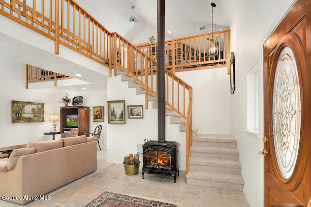 interior space with high vaulted ceiling and a wood stove