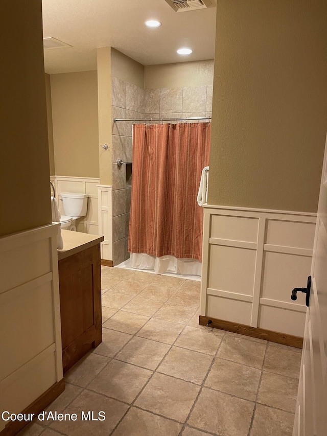 bathroom with tile flooring, vanity, and toilet