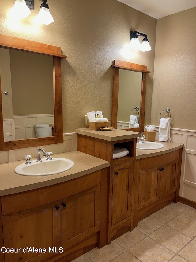 bathroom featuring vanity, toilet, and tile floors