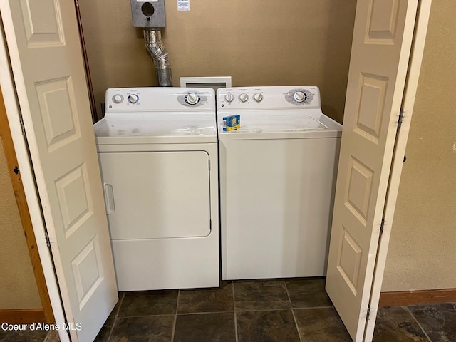 clothes washing area with separate washer and dryer, dark tile flooring, and washer hookup