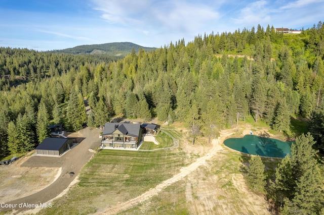 birds eye view of property featuring a forest view and a mountain view