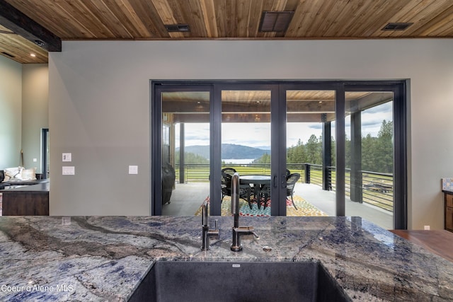 interior space with wooden ceiling, visible vents, and a mountain view