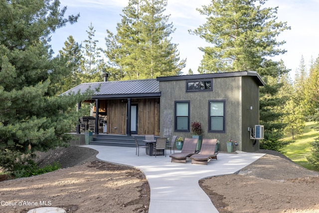 rear view of house with metal roof and a patio