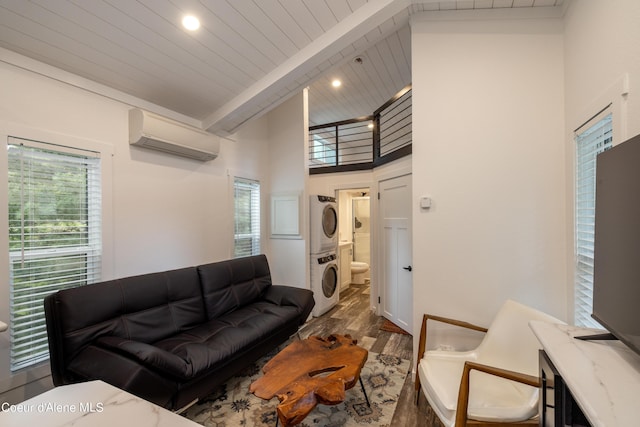 living area featuring a high ceiling, a wall mounted AC, dark wood-type flooring, stacked washer / dryer, and beamed ceiling