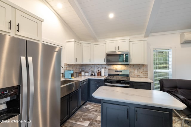 kitchen with stainless steel appliances, backsplash, lofted ceiling with beams, white cabinets, and a sink