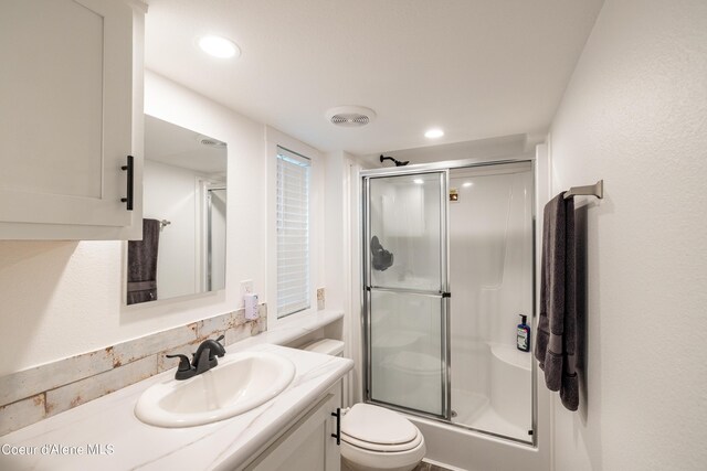 bathroom with a shower with door, recessed lighting, visible vents, toilet, and vanity