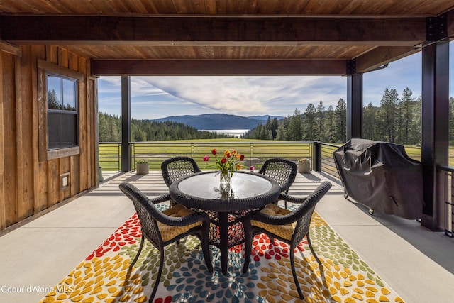 view of patio / terrace featuring a balcony, a grill, a mountain view, and outdoor dining space