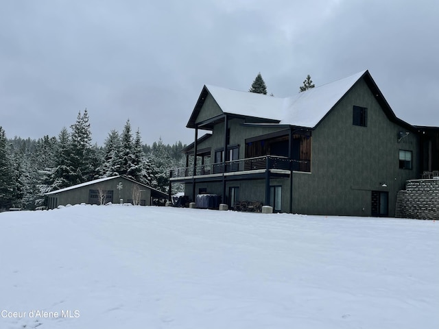 snow covered property with a balcony