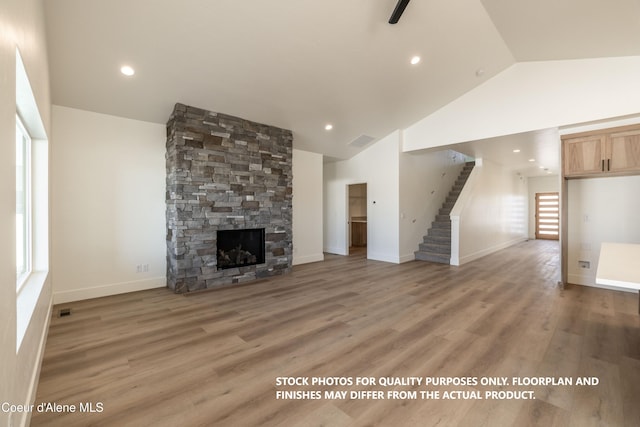 unfurnished living room with high vaulted ceiling, a fireplace, and hardwood / wood-style floors