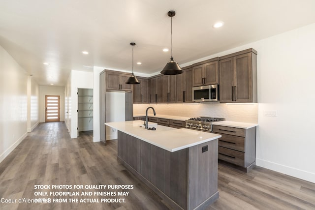 kitchen featuring dark brown cabinetry, sink, tasteful backsplash, and appliances with stainless steel finishes