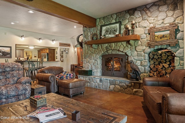 living room featuring beamed ceiling and a stone fireplace