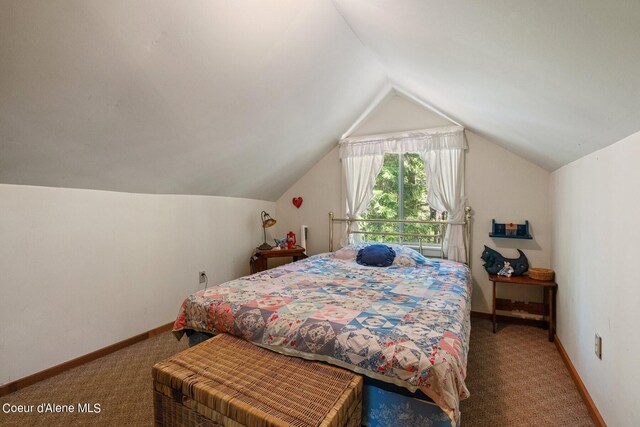 carpeted bedroom with baseboards and lofted ceiling