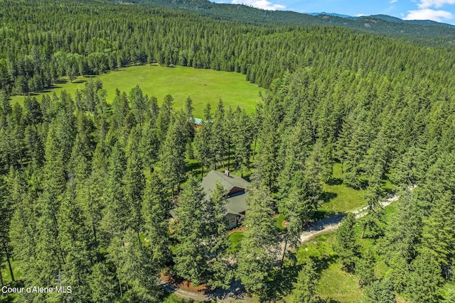 birds eye view of property with a wooded view and a mountain view