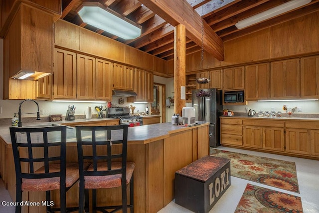 kitchen featuring sink, beamed ceiling, wood walls, a breakfast bar, and black appliances