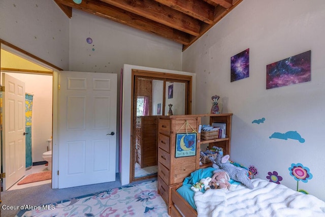 carpeted bedroom with beam ceiling and ensuite bath