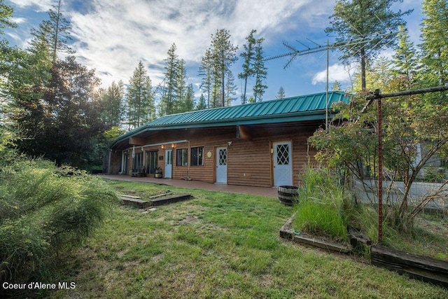 back of house featuring a patio and a lawn