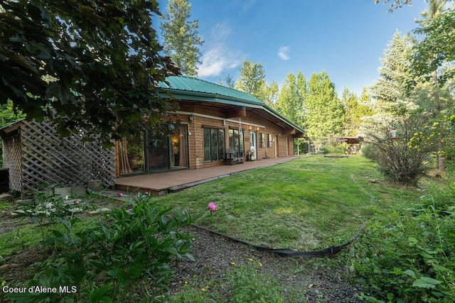 rear view of property with a lawn and a wooden deck