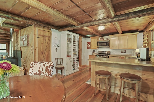 kitchen featuring kitchen peninsula, wooden ceiling, light brown cabinetry, and appliances with stainless steel finishes