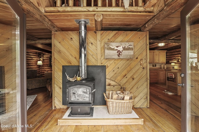 interior details with wood ceiling, a wood stove, log walls, and beamed ceiling