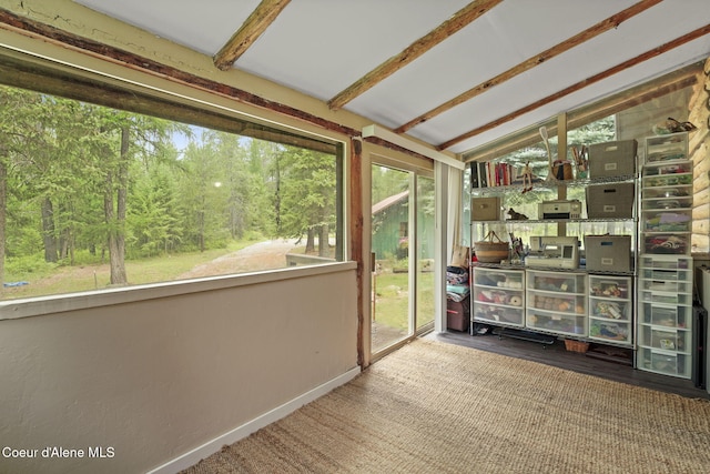 unfurnished sunroom with vaulted ceiling with beams