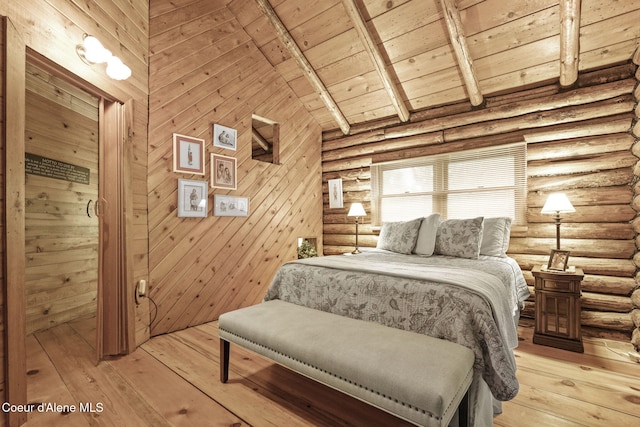 bedroom with beamed ceiling, wooden ceiling, rustic walls, high vaulted ceiling, and light hardwood / wood-style flooring