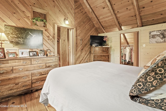 bedroom featuring wood ceiling, vaulted ceiling with beams, wooden walls, a closet, and hardwood / wood-style flooring