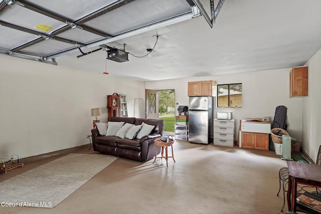 garage featuring stainless steel refrigerator and a garage door opener