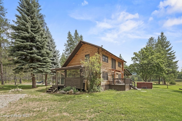 view of side of home featuring a jacuzzi, a sunroom, a yard, and a deck