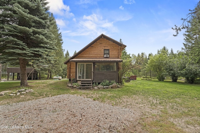 rear view of house featuring a lawn and a sunroom