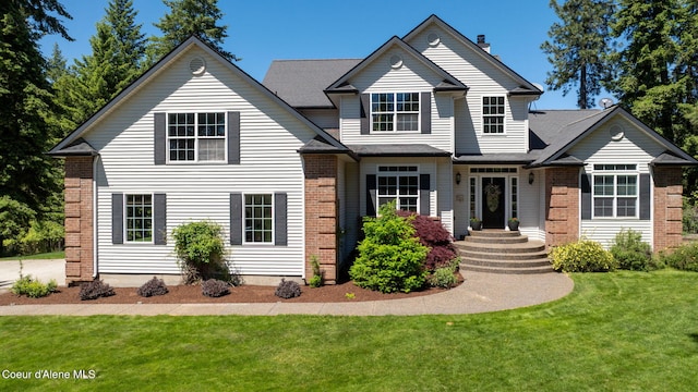17536 W Julia Dr, Hauser, ID 83854 - view of front facade featuring a front yard and brick siding