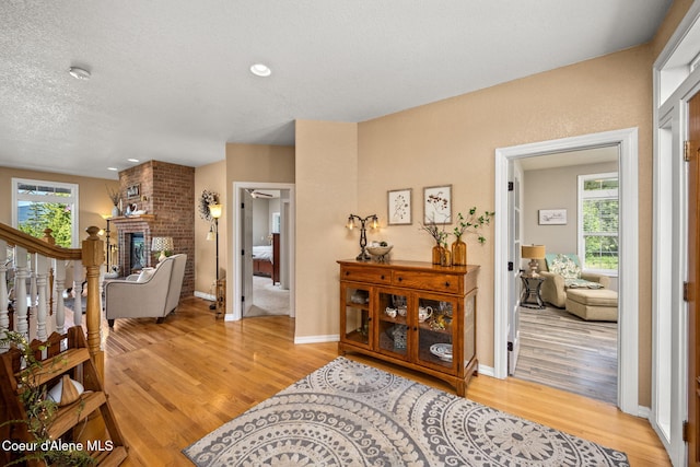 17536 W Julia Dr, Hauser, ID 83854 - entrance foyer featuring light wood-style floors, a fireplace, and a textured ceiling