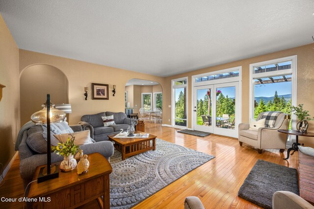 17536 W Julia Dr, Hauser, ID 83854 - living room featuring arched walkways, healthy amount of natural light, and hardwood / wood-style flooring