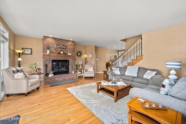 17536 W Julia Dr, Hauser, ID 83854 - living room with wood finished floors, a fireplace, stairway, and a textured ceiling