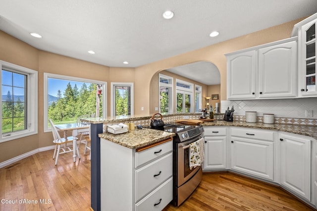 17536 W Julia Dr, Hauser, ID 83854 - kitchen with stainless steel electric range, tasteful backsplash, arched walkways, plenty of natural light, and recessed lighting