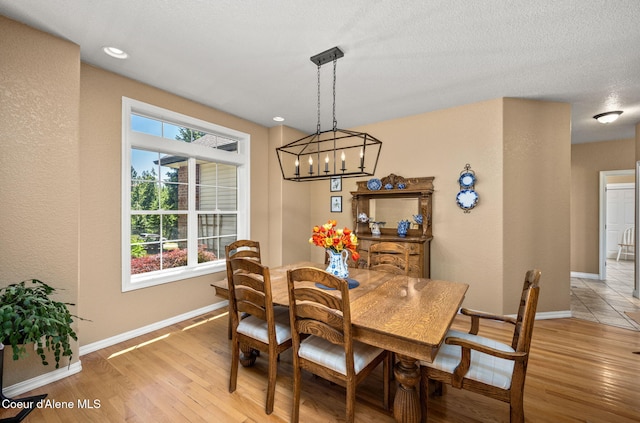 17536 W Julia Dr, Hauser, ID 83854 - dining area featuring light wood-style flooring, a chandelier, and a textured wall