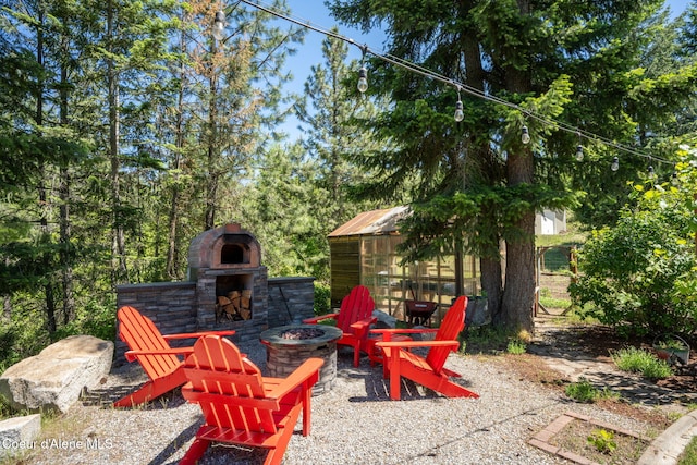 17536 W Julia Dr, Hauser, ID 83854 - view of patio / terrace with an outdoor fire pit and an outdoor stone fireplace