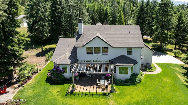 17536 W Julia Dr, Hauser, ID 83854 - rear view of property featuring a chimney, a patio area, a lawn, and a wooden deck