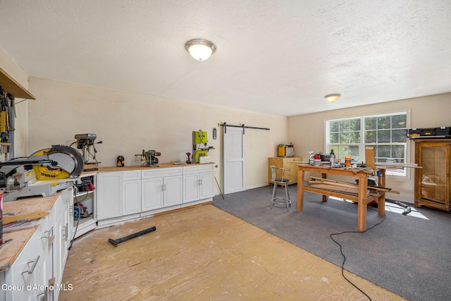 17536 W Julia Dr, Hauser, ID 83854 - kitchen with white cabinets, a textured ceiling, and a barn door