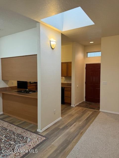 entryway with dark hardwood / wood-style flooring and a skylight