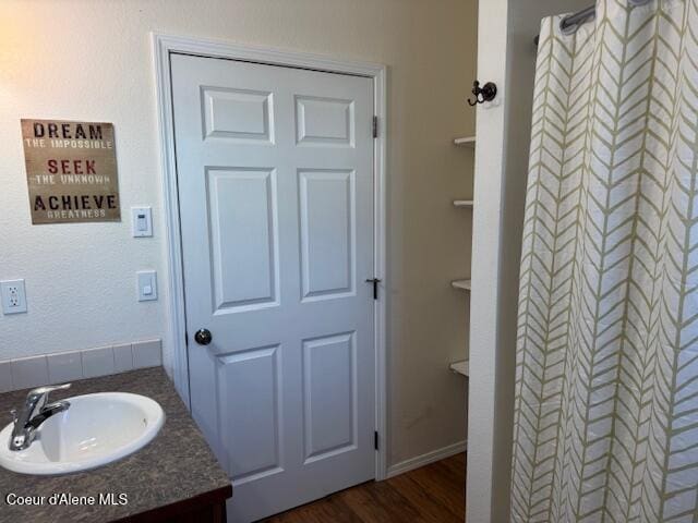 bathroom featuring hardwood / wood-style floors, vanity, and curtained shower