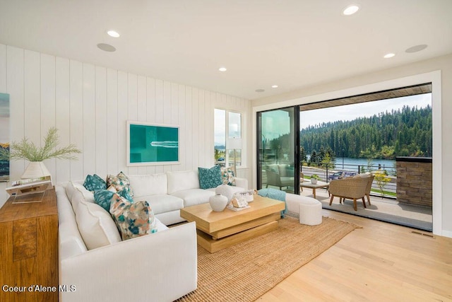 living room with light hardwood / wood-style flooring and wood walls