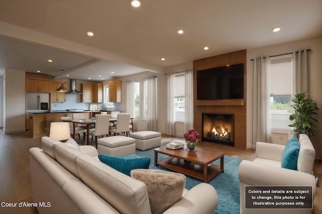 living room with recessed lighting, a fireplace, and wood finished floors