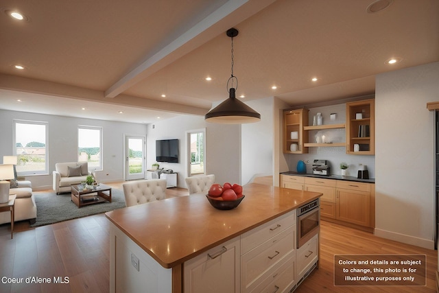 kitchen with light wood-type flooring, beamed ceiling, a healthy amount of sunlight, and open floor plan