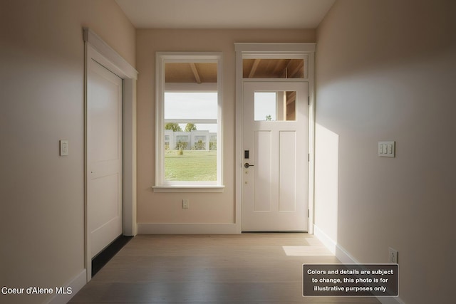 doorway to outside with baseboards and wood finished floors