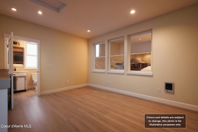 spare room featuring recessed lighting, light wood-style floors, and baseboards