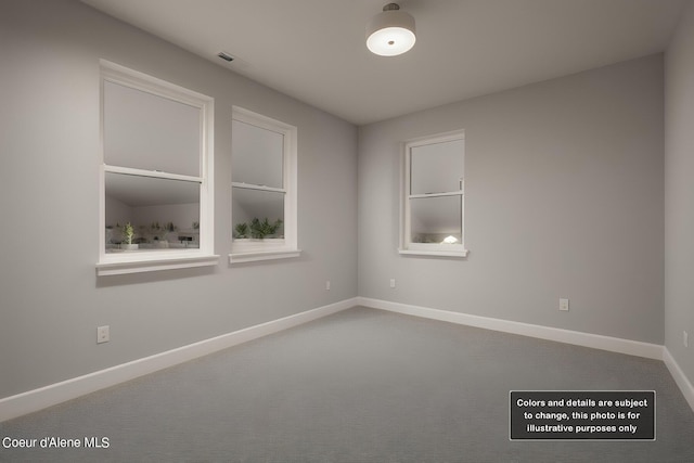 empty room featuring carpet flooring, visible vents, and baseboards